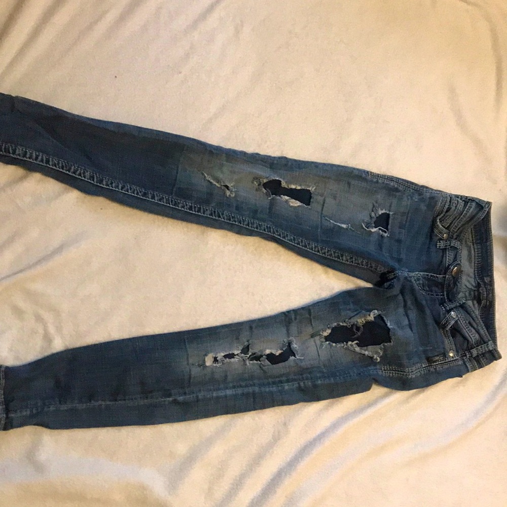 Ripped denim jeans with design on back pockets